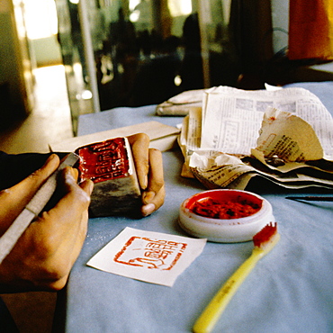 Close-up of a person's hand carving stamp, Xian, China