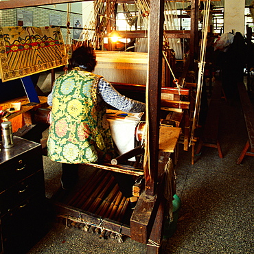 Rear view of a person weaving silk on a loom, Nanjing, Jiangsu Province, China