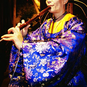 Mid section view of a woman blowing flute, Suzhou, China