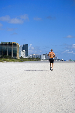 Rear view of a man jogging on the beach, South Beach, Miami Beach, Florida, USA