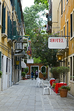 Rear view of two people in front of a hotel on the street, Venice, Italy