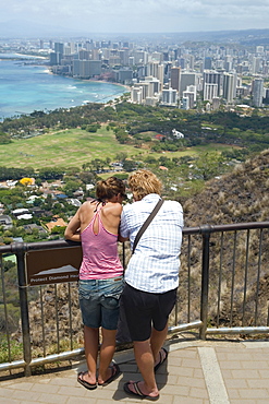 Rear view of a man and a woman standing at an observation point, Diamond Head, Waikiki Beach, Honolulu, Oahu, Hawaii Islands, USA