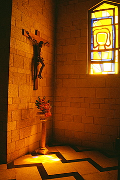 Statue of Jesus Christ on a wall with a flower vase on the floor in a basilica, Basilica Of The Annunciation, Nazareth, Israel