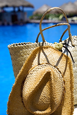 Close-up of a straw hat and a straw bag at the poolside, Cancun, Mexico