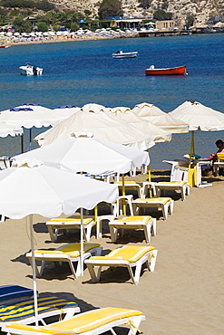 Lounge chairs and beach umbrellas on the beach, Lindos, Rhodes, Dodecanese Islands, Greece