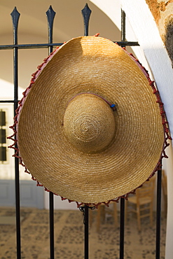 Close-up of a straw hat on a metal fence, Greece