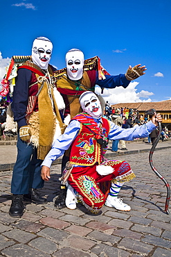 Three people wearing traditional costumes in a festival, Peru