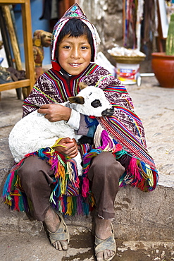 Portrait of a boy holding a lamb and smiling, Pisaq, Urubamba Valley, Peru