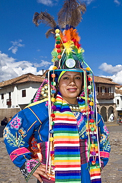 Portrait of a young woman wearing a traditional clothing and standing with arms akimbo, Peru