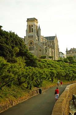 Three people walking on the road, Eglise Sainte Eugenie, Biarritz, France