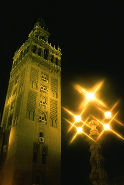 Low angle view of a tower lit up at night, La Giralda, Seville, Andalusia, Spain