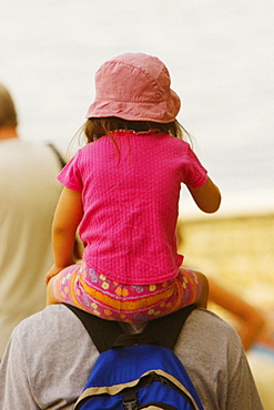 Rear view of a man carrying his daughter on shoulders, Sorrento, Sorrentine Peninsula, Naples Province, Campania, Italy