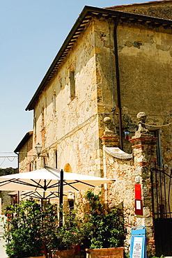 Potted plants and patio umbrellas in front of a building, Piazza Roma, Monteriggioni, Siena Province, Tuscany, Italy