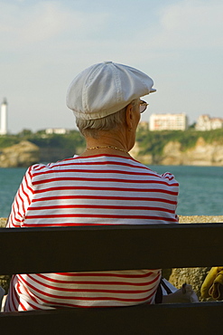 Rear view of a woman sitting on a bench, Phare De Biarritz, Baie De Biarritz, Biarritz, France