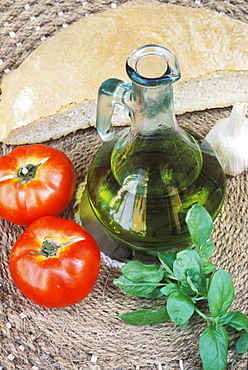 Close-up of a bottle of olive oil and two tomatoes