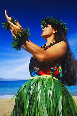 Low angle view of a hula dancer dancing on the beach, Hawaii, USA