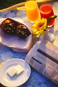 High angle view of two muffins and two glasses of juice near a newspaper