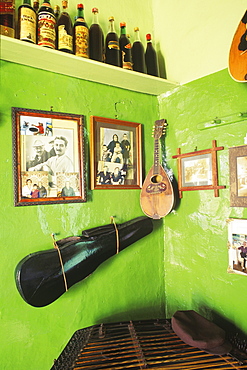 Guitar with picture frames hanging on a wall in a bar