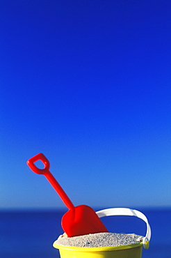 Close-up of a shovel in a sand pail