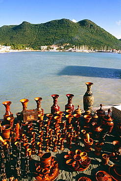 A variety of wooden souvenirs are displayed on a seashore, St. Maarten, Caribbean