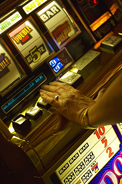 High angle view of a woman's hand operating a slot machine, Las Vegas, Nevada, USA