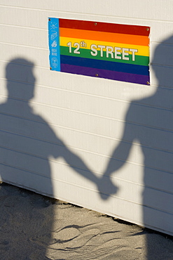 Shadow of two people on a wall holding hands