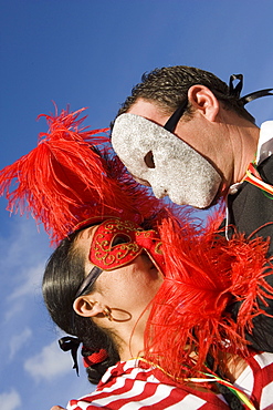 Low angle view of a man and woman wearing masks and looking at each other