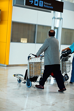 Side profile of a person pushing a luggage cart, Madrid, Spain