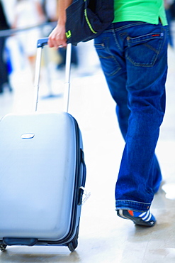 Rear view of a person walking and pulling luggage, Madrid, Spain