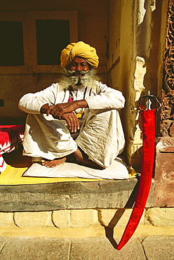 Portrait of a senior man sitting at a veranda of a museum, Meherangarh Museum, Jodhpur, Rajasthan, India