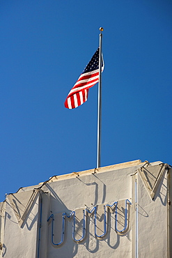 Low angle view of an American flag fluttering on top of a building