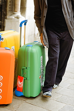 Low section view of a man with suitcases