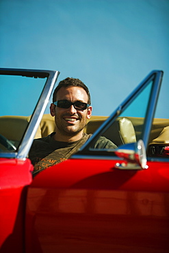 Close-up of a mid adult man sitting in a convertible car, Miami, Florida, USA