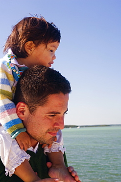 Side profile of a girl riding piggyback on her father