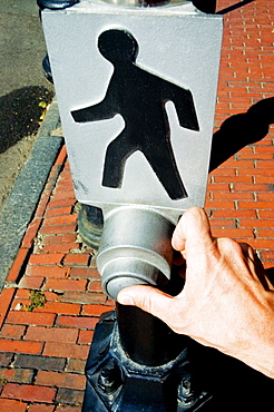 High angle view of person's hand pressing the button of a pedestrian crossing sign, Beacon Street, Boston, Massachusetts, USA