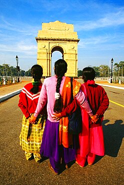 Rear view of three women standing in front of India Gate, New Delhi, India