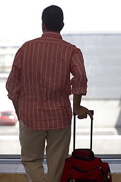 Rear view of a man standing and holding a bag, Madrid, Spain