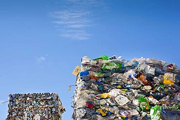 Commercial waste management, bales of recycling materials, plastics stacked up.