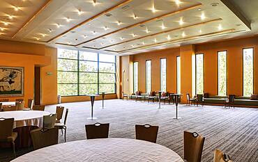 Large empty room in a hotel or conference centre, tables and chairs.