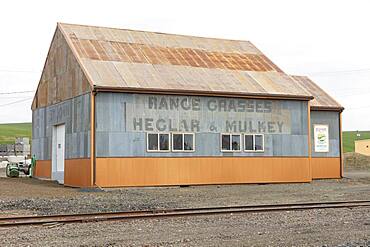 Farm equipment building in a rural setting, deserted.