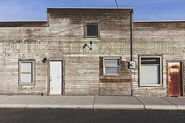 Old wooden building on Main Street, boarded up windows.