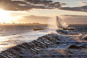 A weather storm in the Baltic Sea, waves crashing over a pier