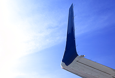 Aircraft wingtip, low angle view, against blue sky.