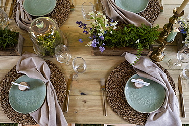 High angle close up of rustic place settings for a woodland naming ceremony.