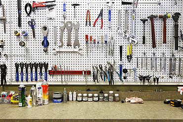 Cycle repair shop interior, tool boards and tools at a service counter.