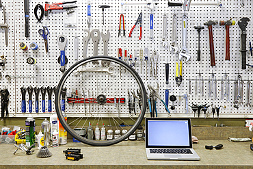 Cycle repair shop interior, tool boards and tools at a service counter.