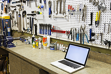 Cycle repair shop interior, tool boards and tools at a service counter.