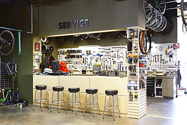 Cycle repair shop interior, tool boards and tools at a service counter.