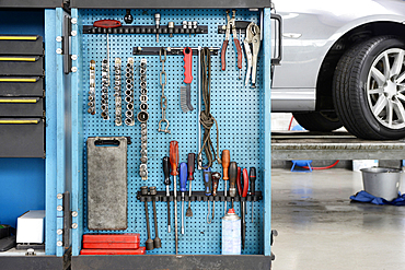 Tools in a cabinet, organised in rows, at an auto repair shop