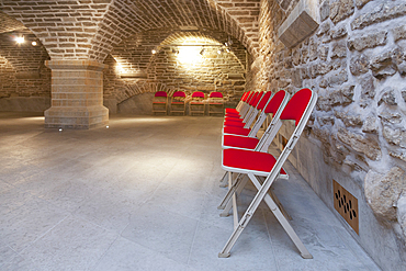 Chairs in a vaulted stone room for lectures meetings or seminars at a university